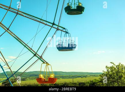 Riesenradkabinen in Nahaufnahme auf dem blauen Himmel Hintergrund. Szenische Ansicht des Details des farbigen Riesenrads. Konzept von Urlaub und Kinder`s amusemen Stockfoto
